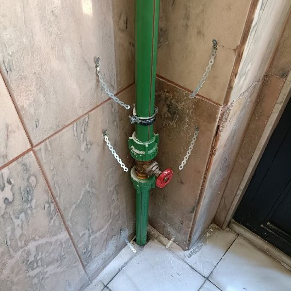 Registro de aguas Tubería verde vertical con una llave de paso en una esquina